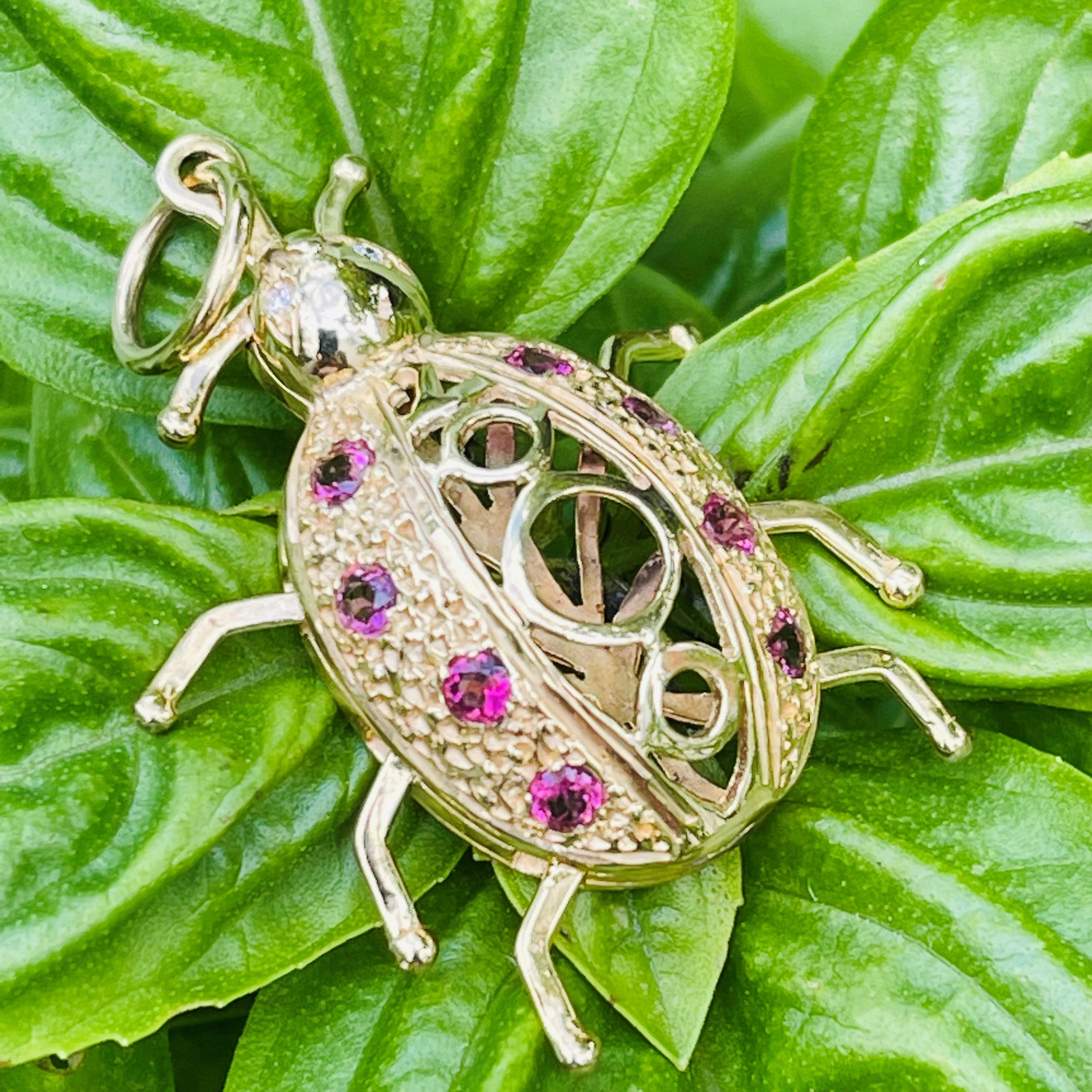 Artfully Articulated Diamond & Tourmaline Millennium Ladybird Pendant photographed on green leaves