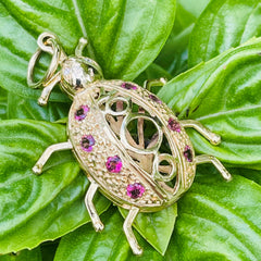 Artfully Articulated Diamond & Tourmaline Millennium Ladybird Pendant photographed on green leaves