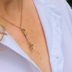 1973 Gold & Pearl Golf Clubs Necklace photographed on a model wearing a white shirt