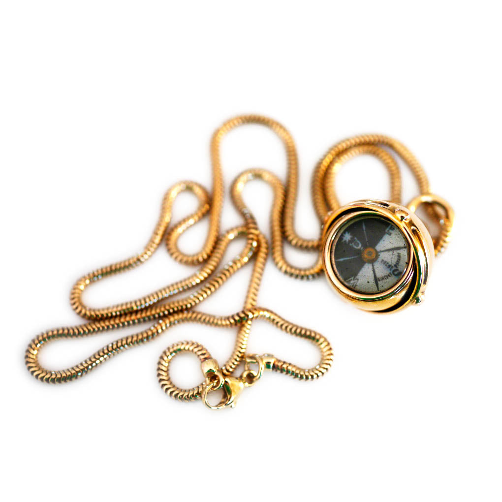 Antique Articulated Gold Gimbal Orb Compass Pendant on a gold chain photographed on a white background