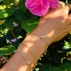 Vintage Blue Topaz Bracelet worn on models wrist. Pink flowered shrubbery in the background.