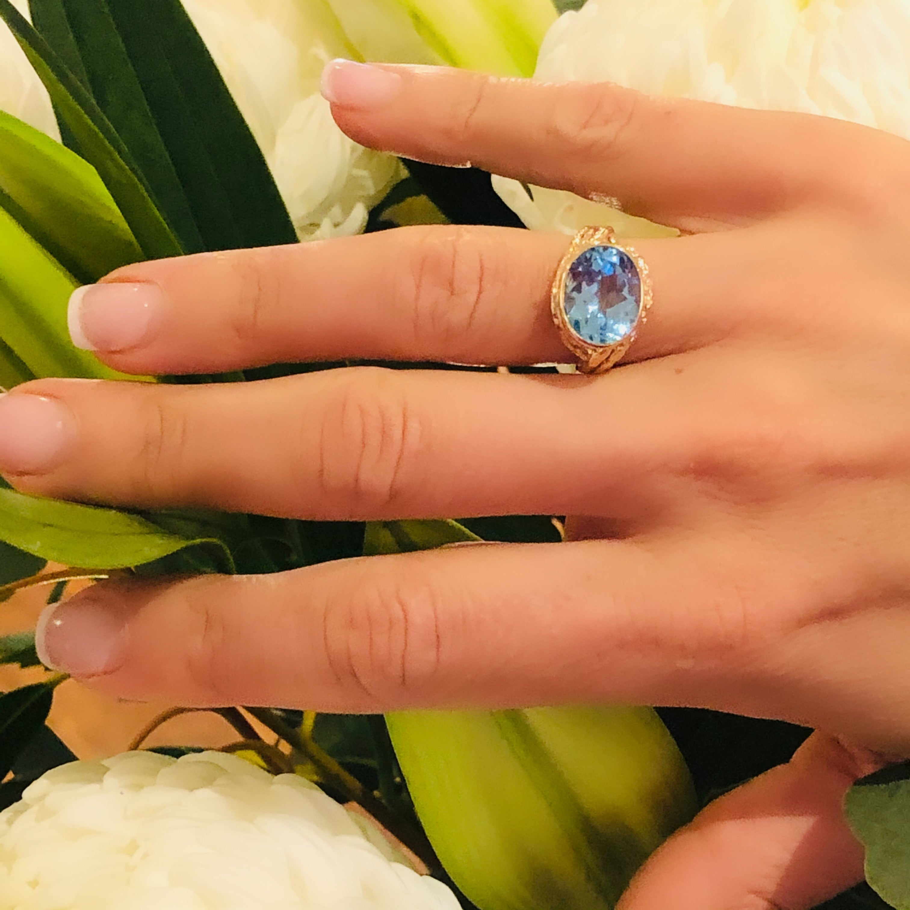 Vintage 1970s Blue Topaz Dress Ring photographed on models ring finger. plant in background.