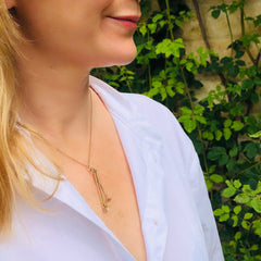 1973 Gold & Pearl Golf Clubs Necklace photographed on a model wearing a white shirt